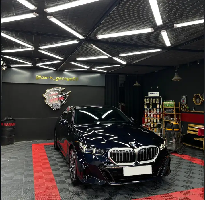 Dark Garage 59 stüdyosunda LED ışıklar altında lacivert BMW 5 Serisi